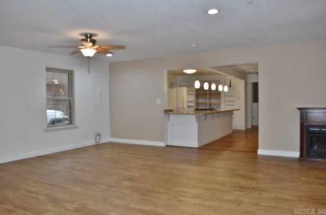 unfurnished living room with ceiling fan and light hardwood / wood-style floors