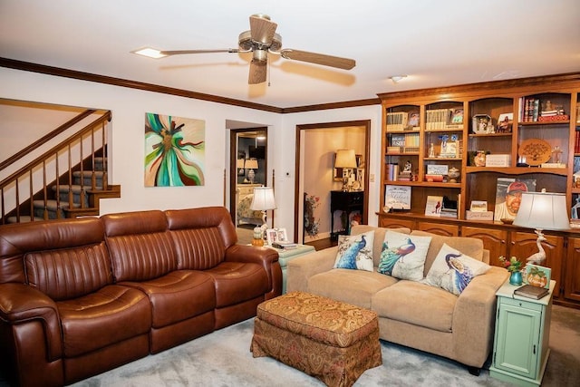 living room with ceiling fan, ornamental molding, and light colored carpet