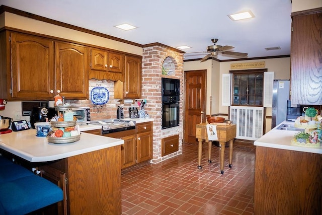 kitchen featuring tasteful backsplash, black appliances, a kitchen breakfast bar, ornamental molding, and kitchen peninsula