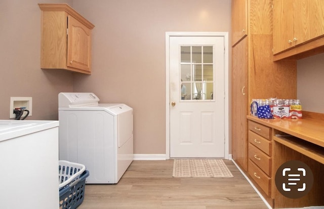 laundry room featuring cabinets, washer and dryer, and light wood-type flooring