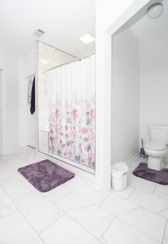 bathroom with toilet and a shower with curtain