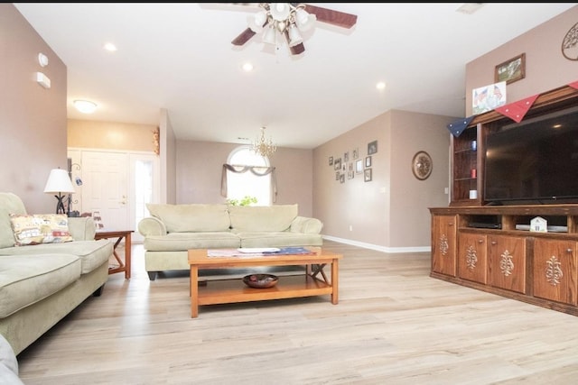 living room with ceiling fan with notable chandelier and light wood-type flooring