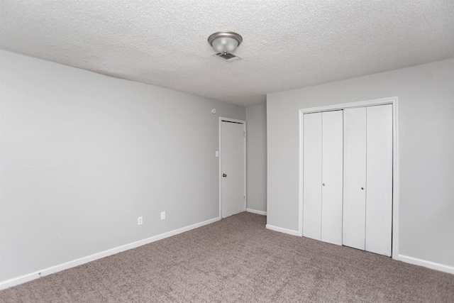 unfurnished bedroom with carpet floors, a textured ceiling, and a closet