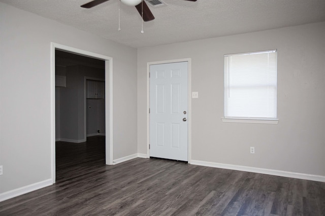 spare room with ceiling fan, dark wood-type flooring, and a textured ceiling