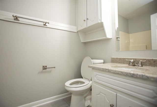 bathroom featuring vanity, walk in shower, tile patterned floors, and toilet