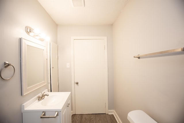 bathroom featuring vanity, hardwood / wood-style floors, and toilet