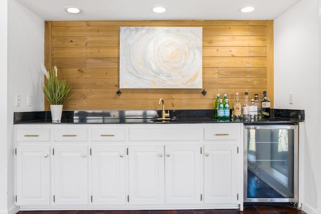 bar featuring wine cooler, white cabinetry, and sink