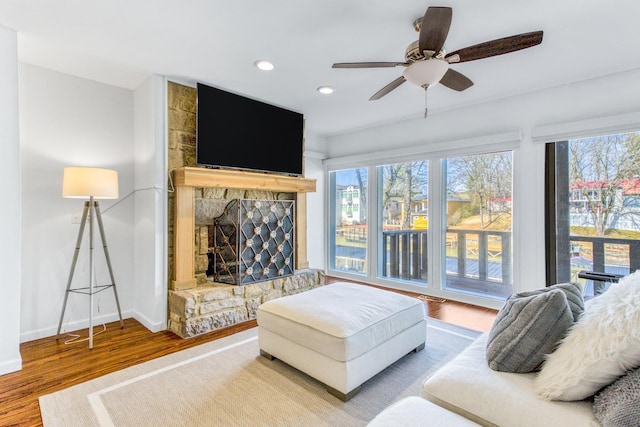 living room featuring hardwood / wood-style flooring, a fireplace, and ceiling fan