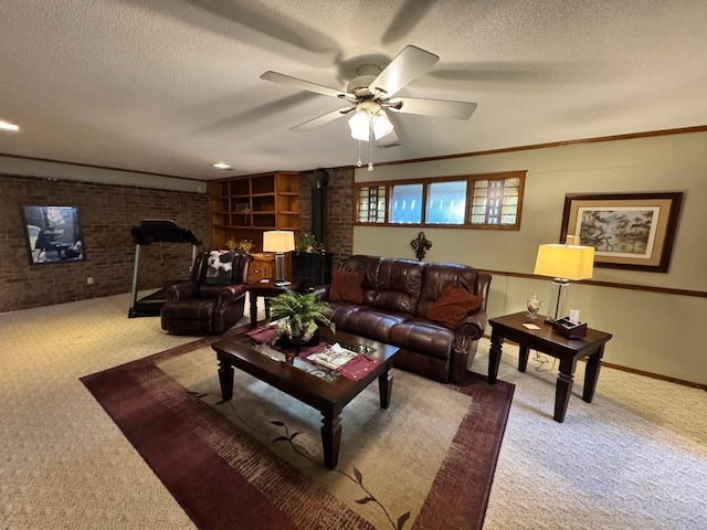 living room featuring brick wall, carpet flooring, a textured ceiling, and a wood stove