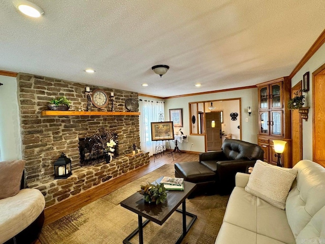 living room with ornamental molding, a fireplace, hardwood / wood-style floors, and a textured ceiling