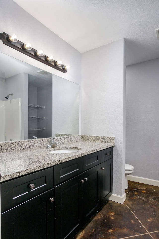 bathroom with vanity, a textured ceiling, and toilet