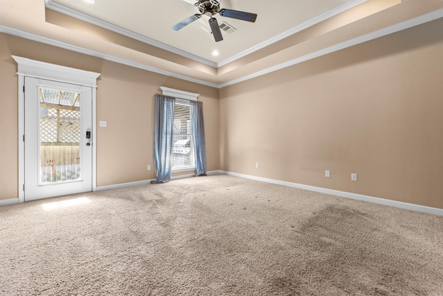 carpeted spare room with a tray ceiling, ornamental molding, and ceiling fan