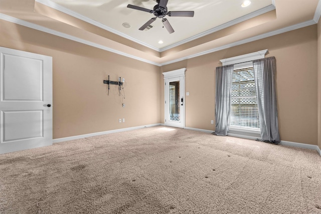 unfurnished room featuring a raised ceiling, ornamental molding, carpet flooring, and ceiling fan