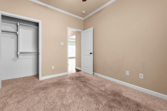 unfurnished bedroom featuring crown molding, carpet, and a closet