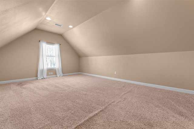 bonus room featuring vaulted ceiling and carpet