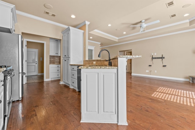 kitchen featuring sink, white cabinetry, light stone counters, stainless steel range oven, and a raised ceiling