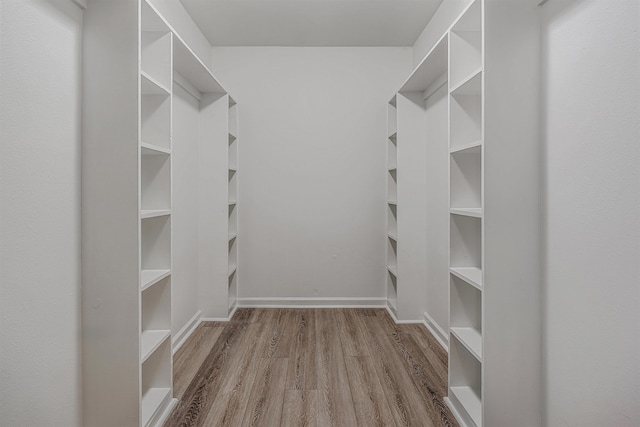 walk in closet with light hardwood / wood-style flooring