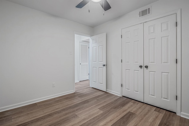 unfurnished bedroom with ceiling fan, light hardwood / wood-style floors, and a closet