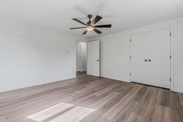 unfurnished bedroom with ceiling fan, light hardwood / wood-style floors, and a closet