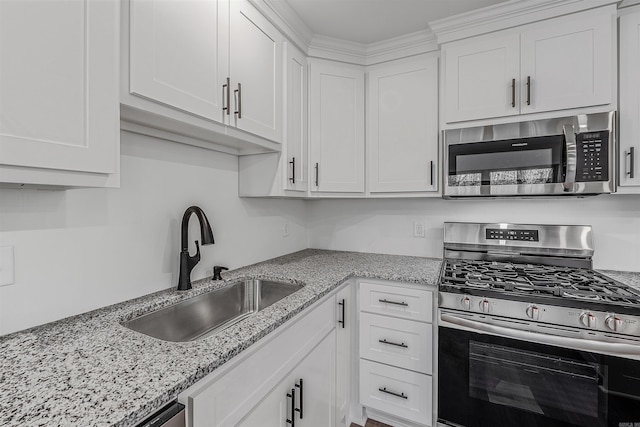 kitchen with white cabinetry, sink, stainless steel appliances, and light stone countertops