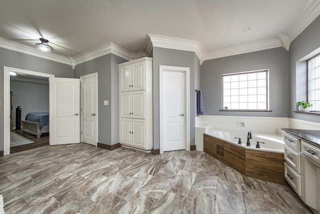 bathroom featuring tiled tub, crown molding, and vanity