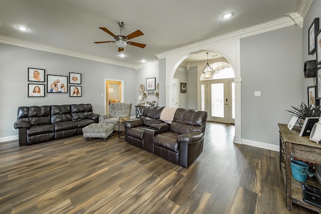 living room featuring ornamental molding, dark hardwood / wood-style floors, and ceiling fan with notable chandelier