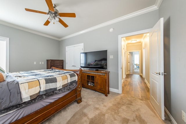 bedroom featuring crown molding, a closet, ceiling fan, and light carpet