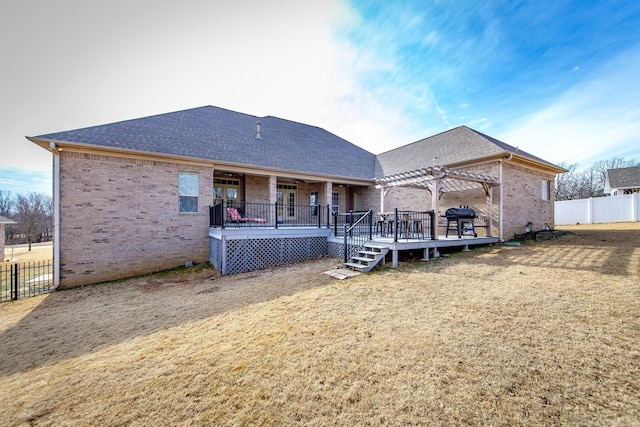 back of property featuring a yard, a deck, and a pergola