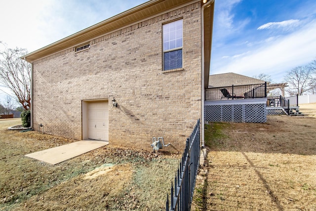 rear view of house featuring a garage, a lawn, and a deck