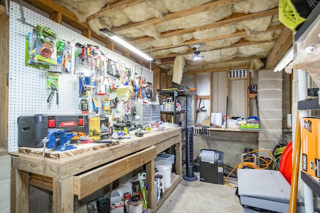 miscellaneous room featuring a workshop area and concrete floors