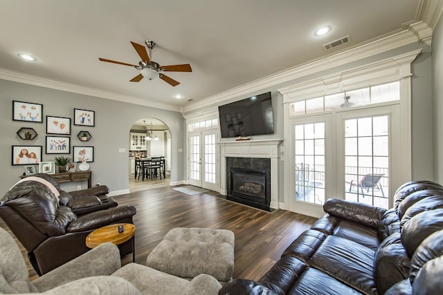 living room with ornamental molding, a healthy amount of sunlight, and dark hardwood / wood-style flooring