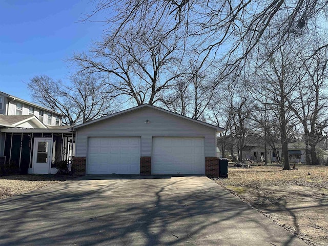 view of side of property with an outbuilding, a garage, and a sunroom