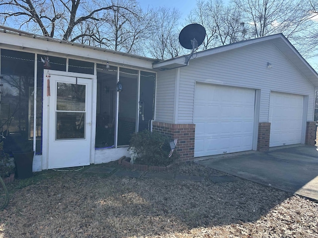 exterior space with a garage and a sunroom