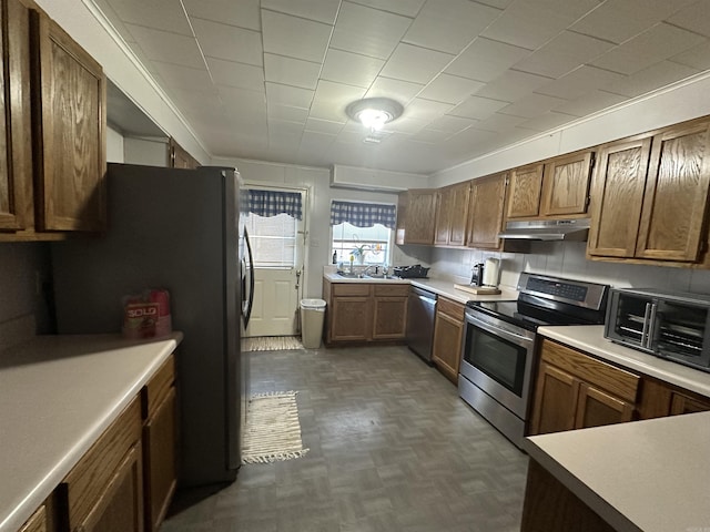 kitchen with stainless steel appliances, sink, and dark parquet flooring