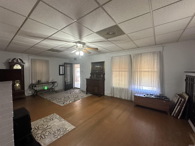 unfurnished living room with a paneled ceiling, hardwood / wood-style floors, and ceiling fan