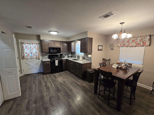 kitchen with decorative light fixtures, sink, dark hardwood / wood-style flooring, black appliances, and dark brown cabinets