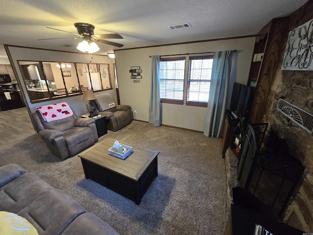 carpeted living room featuring crown molding, ceiling fan, and a textured ceiling