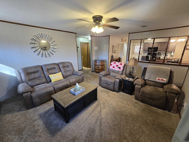 carpeted living room featuring ceiling fan, crown molding, and a textured ceiling