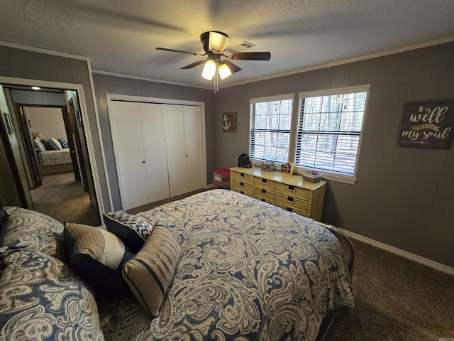 carpeted bedroom with ceiling fan, ornamental molding, a closet, and a textured ceiling