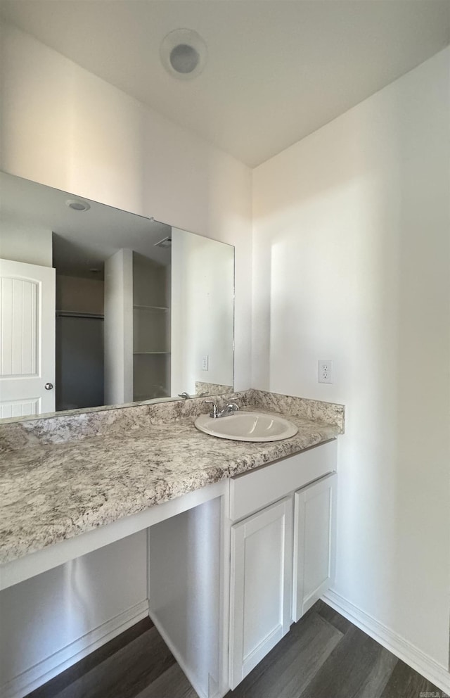 bathroom with vanity, wood finished floors, and baseboards