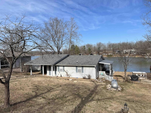 rear view of property featuring a water view and a yard