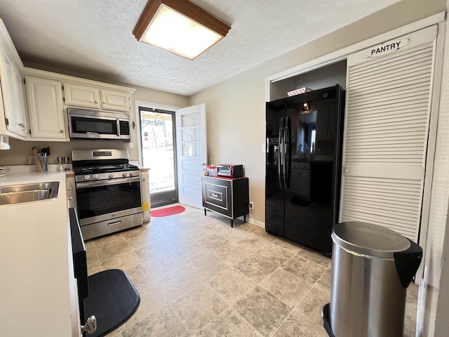 kitchen featuring stainless steel appliances, sink, and a textured ceiling