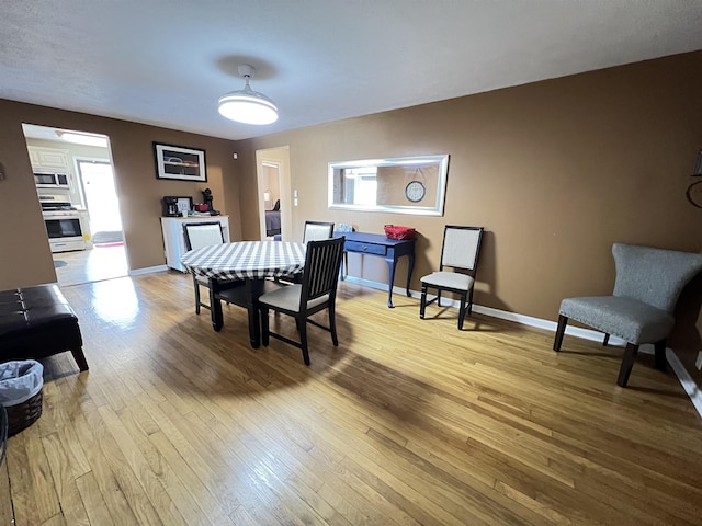 dining space with a wealth of natural light and light wood-type flooring