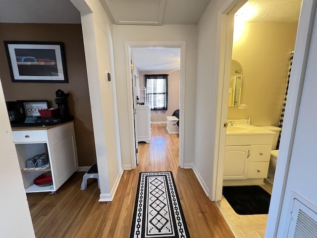 hall featuring sink and light hardwood / wood-style flooring