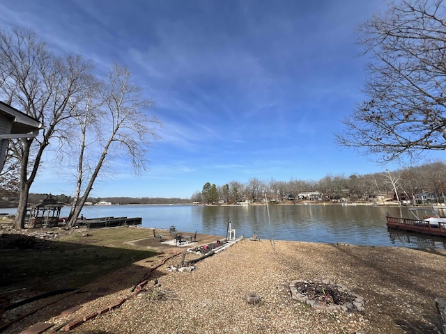 view of dock with a water view and a fire pit