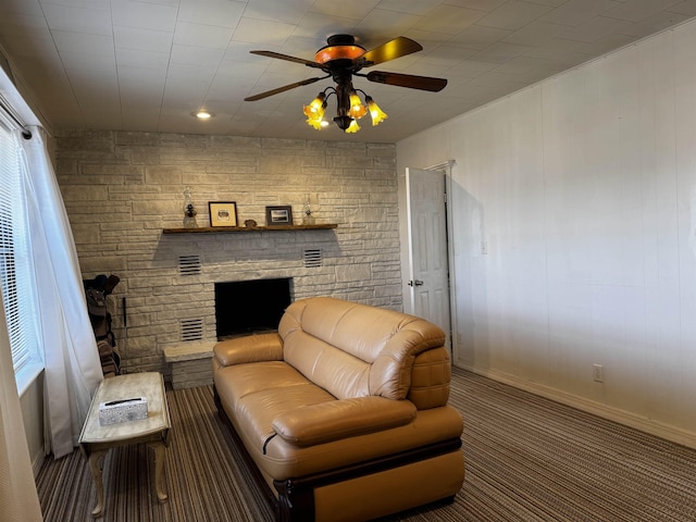 carpeted living room with a fireplace and ceiling fan