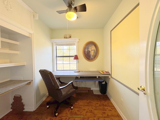 office space with ceiling fan, dark hardwood / wood-style floors, and built in desk