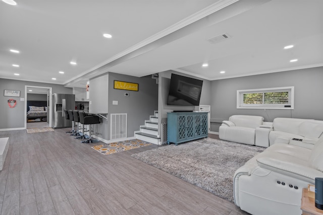 living room featuring crown molding and light wood-type flooring