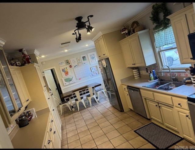 kitchen featuring sink, crown molding, light tile patterned floors, black refrigerator, and stainless steel dishwasher