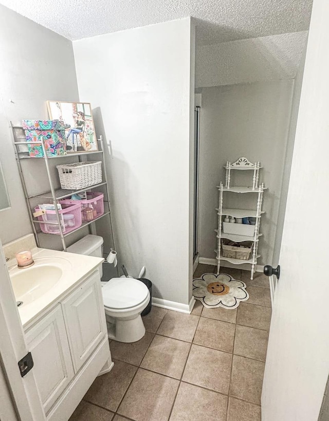 bathroom featuring vanity, an enclosed shower, tile patterned flooring, and a textured ceiling